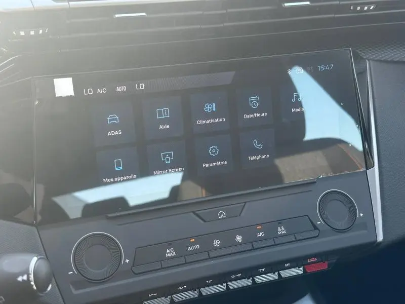 Écran tactile central de la Peugeot 308 bleu, vue rapprochée du tableau de bord avec commandes climatisation et multimédia.