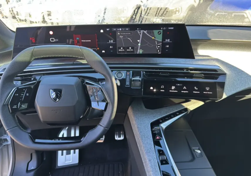 Vue intérieure du tableau de bord du Peugeot 3008 Hybrid 2025 avec volant cuir multifonctions et écran tactile panoramique.