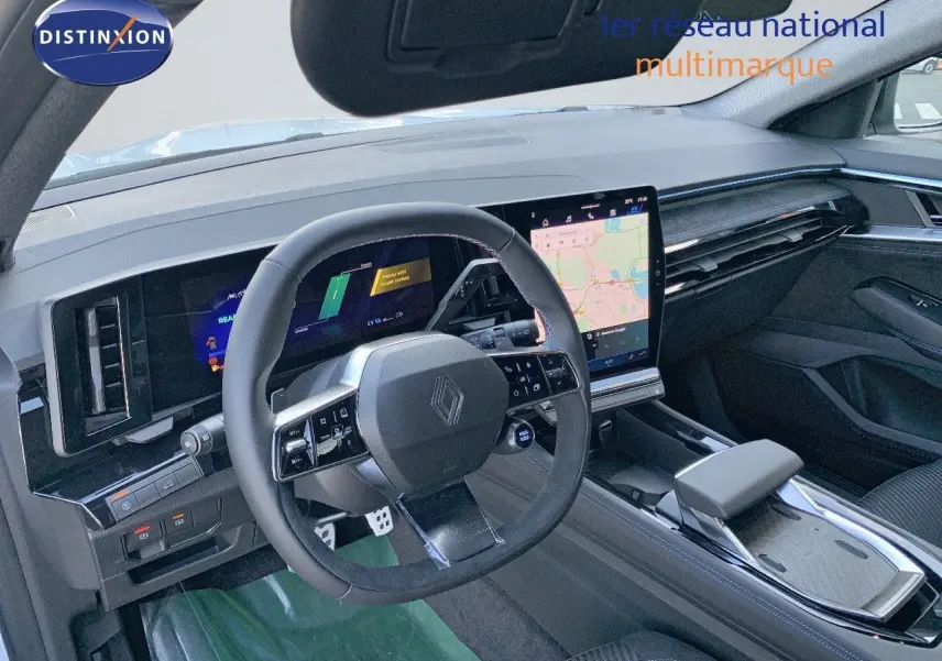 Intérieur du Renault Austral 2024 vu côté conducteur, tableau de bord noir avec écran tactile central et volant multifonction.