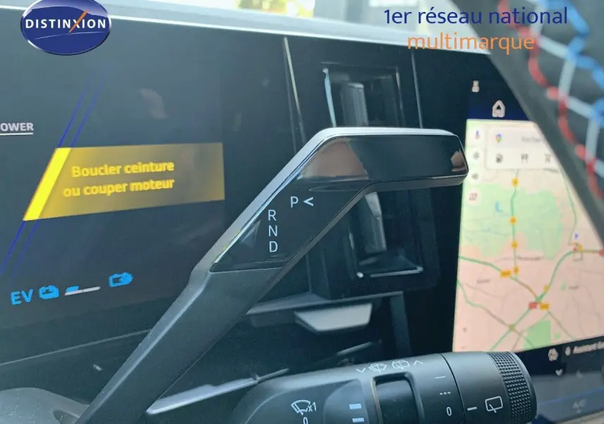 Le levier de vitesses automatique noir du Renault Austral 2024 en gros plan, avec l'écran tactile de navigation en arrière-plan.