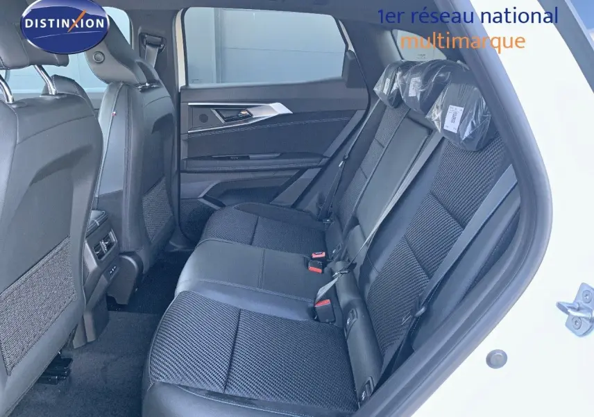 Vue latérale droite de l'habitacle arrière du Renault Austral 2024 blanc métal avec sièges noirs en cuir et tissu.