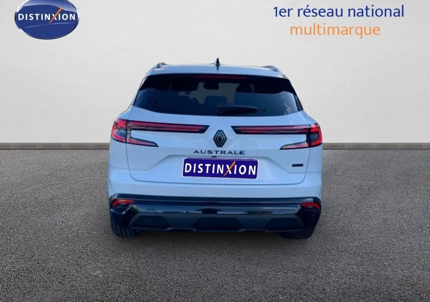 Vue arrière d'un Renault Austral blanc métal avec toit noir, mettant en valeur ses feux LED horizontaux et son badge distinctif.