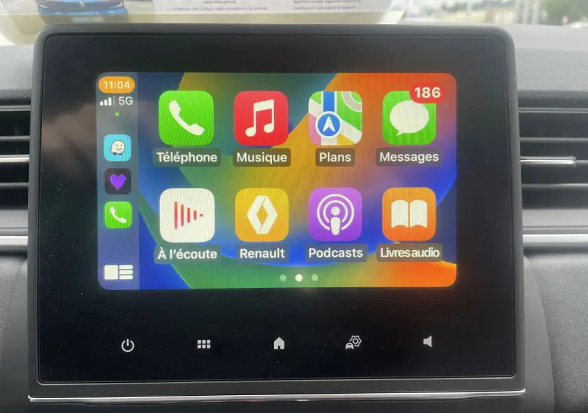 Écran tactile central affichant l'interface multimédia Apple CarPlay dans un Renault Captur bleu métal 2022.