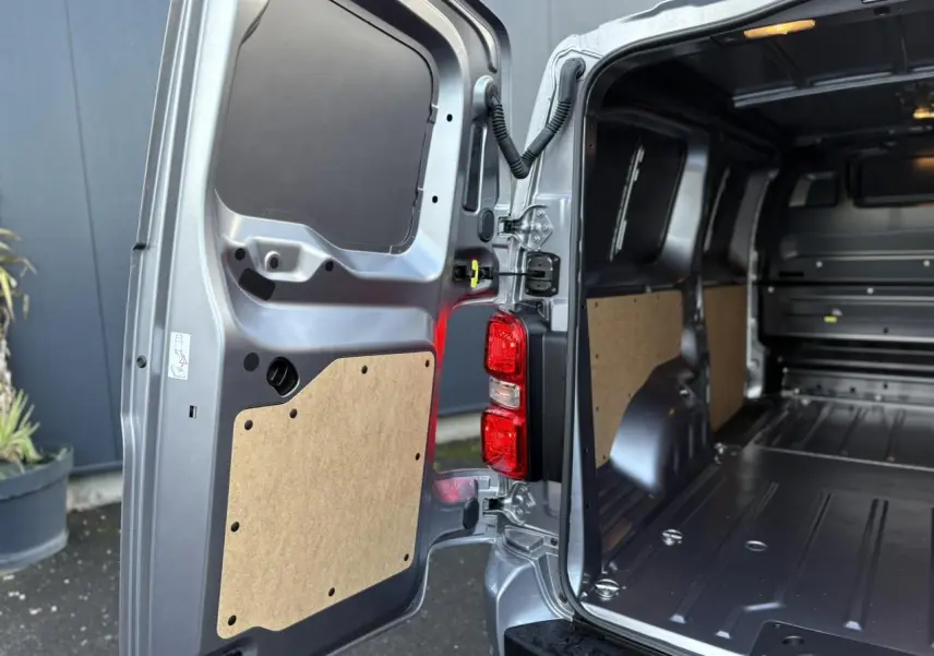 Vue arrière ouverte côté droit du Citroën Jumpy XL gris Artense, montrant l'espace de chargement vide et les panneaux intérieurs en bois.