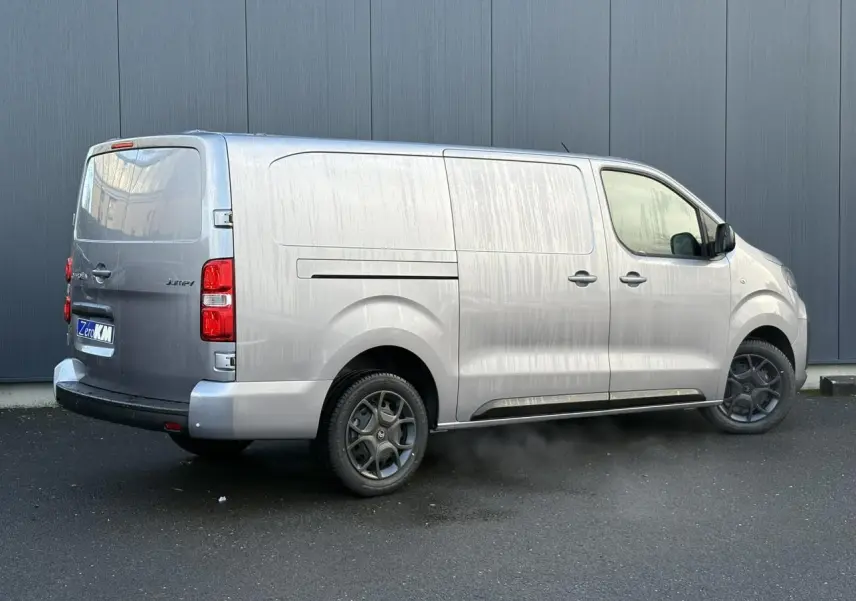 Vue 3/4 arrière droite du Citroën Jumpy XL gris Artense avec bouclier arrière demi-peint et jantes spécifiques.
