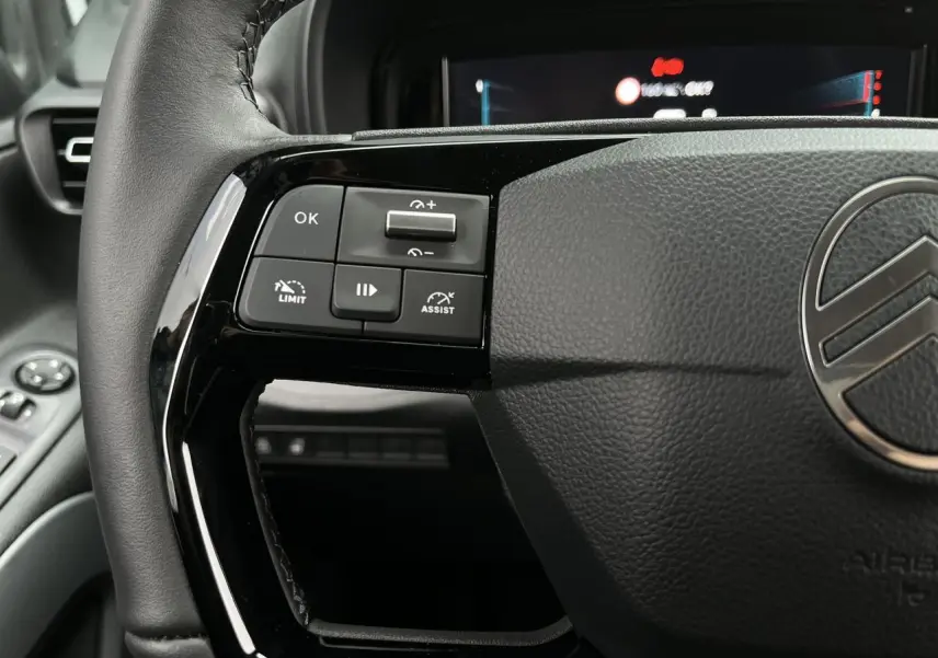 Gros plan sur le volant cuir noir du Citroën Berlingo Multispace 2025 avec commandes multifonctions à gauche.