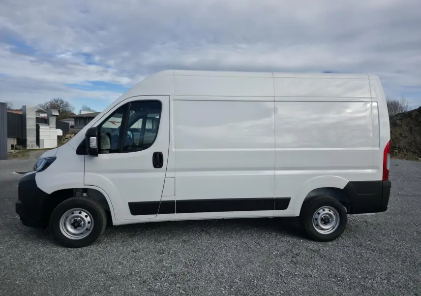 Vue latérale droite du fourgon blanc FIAT Ducato Tôlé 3.3 L H2 2025 avec roues acier et protections noires.