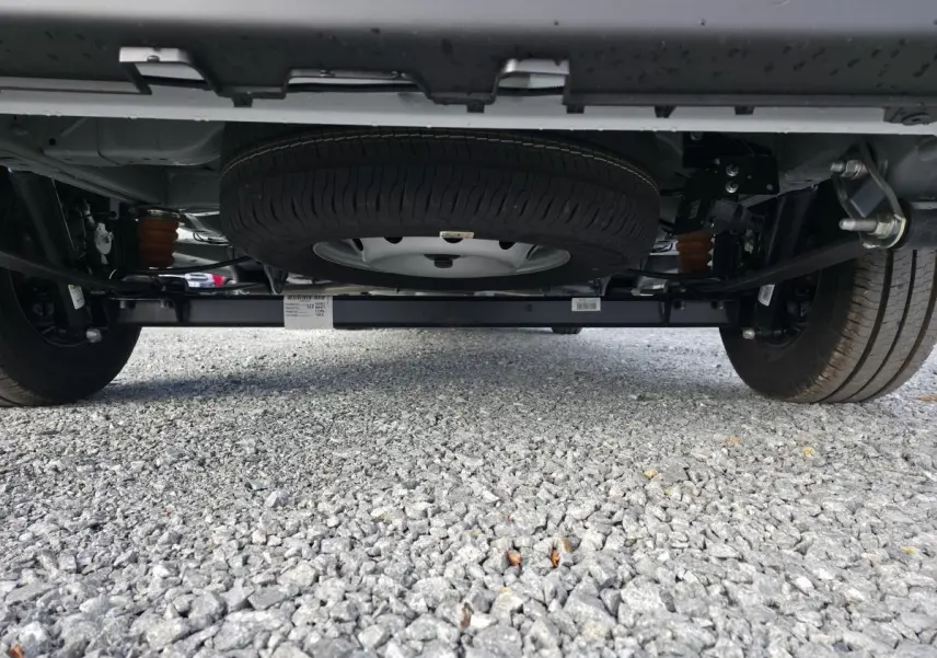 Vue en contre-plongée sous le Fiat Ducato Fourgon blanc, mettant en valeur la roue de secours et le châssis arrière.