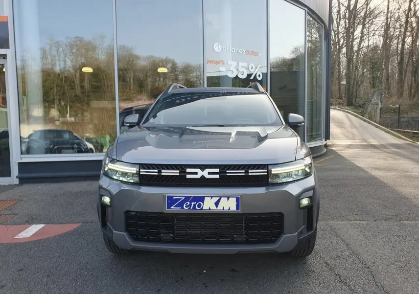 Vue avant d'un Dacia Bigster gris schiste avec signature lumineuse LED et toit panoramique visible en arrière-plan.