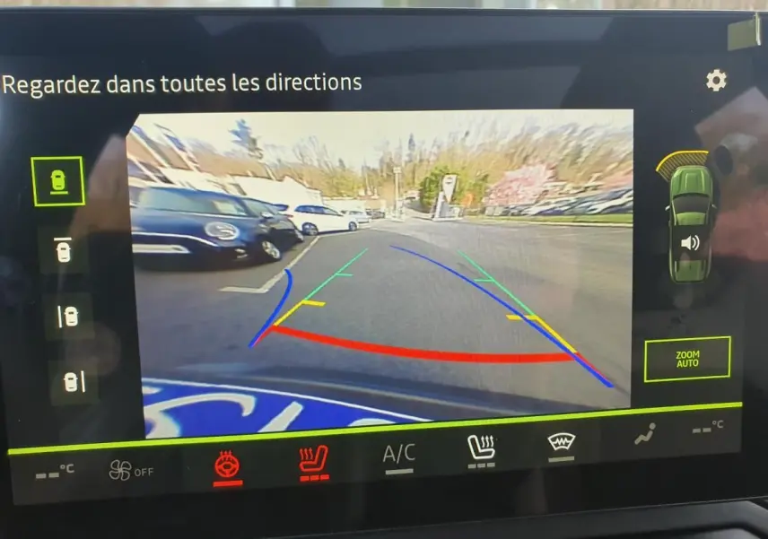 Vue arrière caméra de recul du Dacia Bigster gris schiste avec lignes de guidage colorées et capteurs de stationnement actifs.