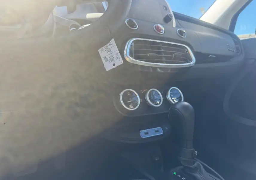 Intérieur de la Fiat 500X bleu, vue côté conducteur sur la console centrale avec levier de vitesse automatique et commandes de climatisation.