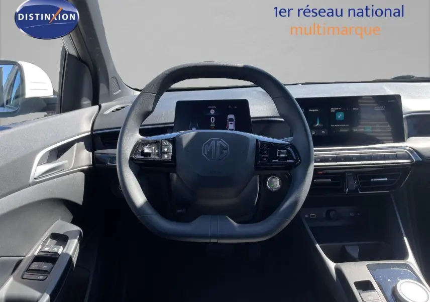 Vue intérieure centrée sur le volant MG d'une MG3 Dover White 2025, avec tableau de bord numérique et écran tactile.