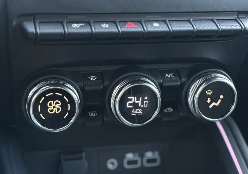 Gros plan sur les commandes de climatisation automatique de la Renault Clio 2025, avec affichage digital à 24°C.
