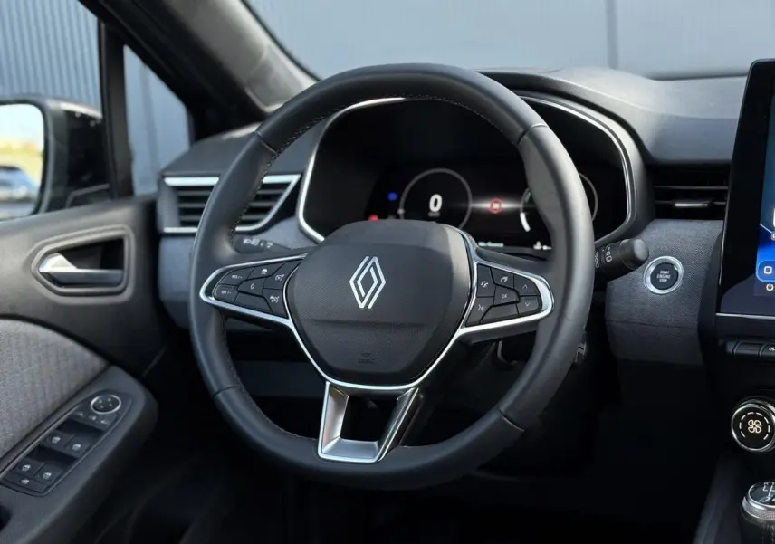 Vue intérieure centrée sur le volant multifonction noir de la Renault Clio 2025 avec tableau de bord numérique.