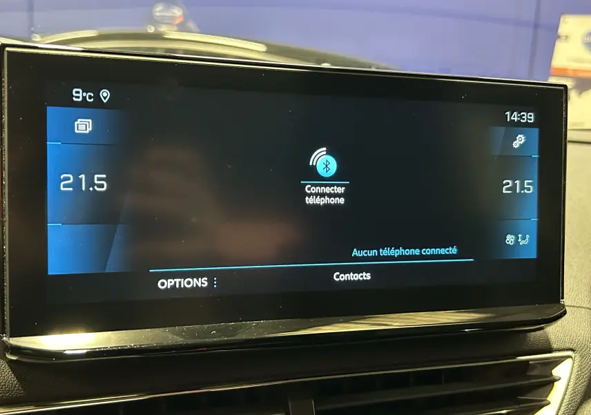 Écran tactile central du tableau de bord du Peugeot 3008 gris, affichant la connexion Bluetooth et la température à 21,5°C.