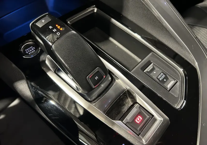 Gros plan sur la console centrale du Peugeot 3008 gris, montrant le levier de vitesse automatique et les commandes électroniques.