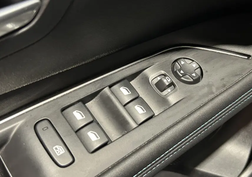 Détail des commandes de lève-vitres et réglages des rétroviseurs sur la porte avant gauche du Peugeot 3008 gris Artense.