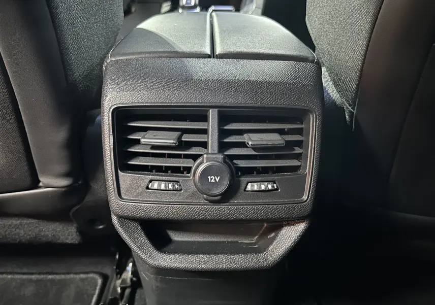 Gros plan sur la sortie d’air arrière avec prise 12V du Peugeot 3008 gris Artense, intérieur noir.