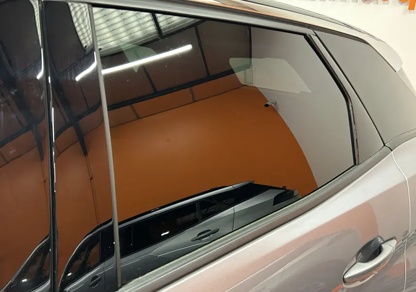 Vue latérale droite du Peugeot 3008 gris Artense avec toit noir, mettant en valeur la porte arrière et la vitre teintée.