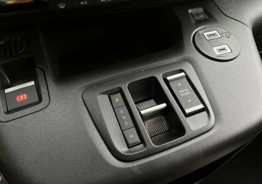 Gros plan sur la console centrale noire du Citroën Berlingo Multispace 2025, avec commandes de boîte auto et mode de conduite.