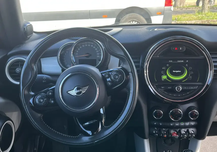 Vue intérieure du tableau de bord et volant noir de la MINI Cabriolet F57 Cooper S avec écran central affichant la navigation.