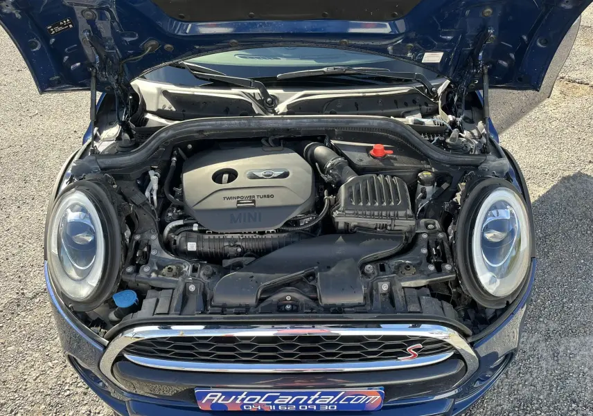 Vue plongeante sur le moteur d’une MINI Cabriolet F57 Cooper S bleu, capot ouvert et calandre avec logo "S" rouge visible.