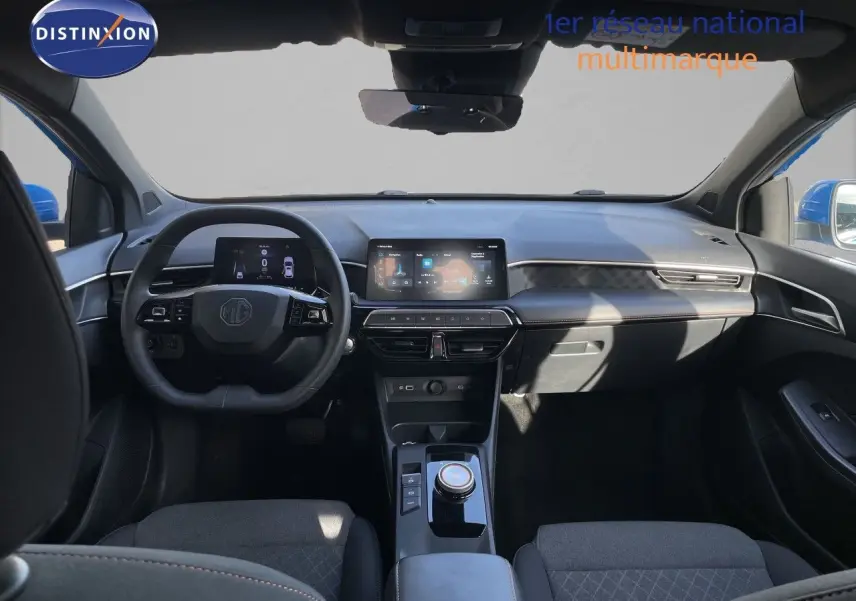 Vue intérieure avant du MG3 1.5L HYBRID+ 2024 en tissu noir, avec tableau de bord numérique et écran tactile central.