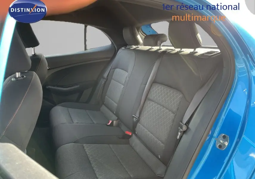 Vue intérieure sur les sièges arrière en tissu noir de la MG3 2024, porte ouverte côté droit, carrosserie bleu COMO visible.