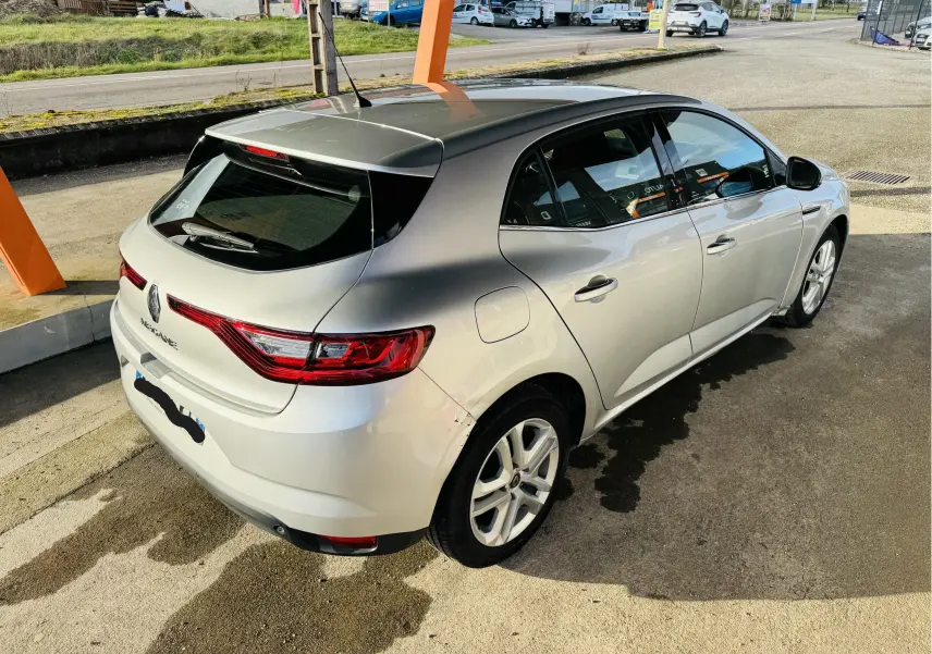 Renault Mégane IV berline gris vue 3/4 arrière droit, avec feux arrière LED et toit noir brillant.