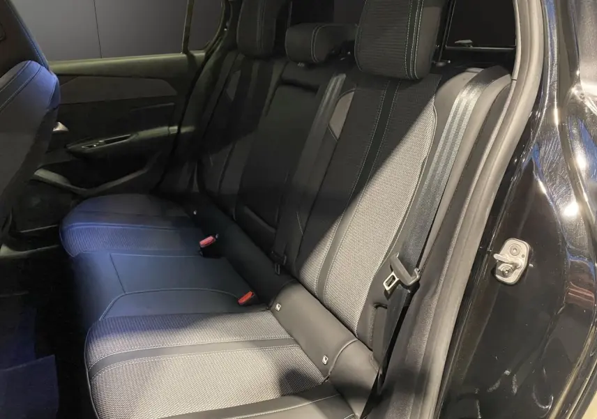 Vue intérieure côté droit des sièges arrière en tissu noir et cuir de la Peugeot 308 2024 noir Perla Nera.
