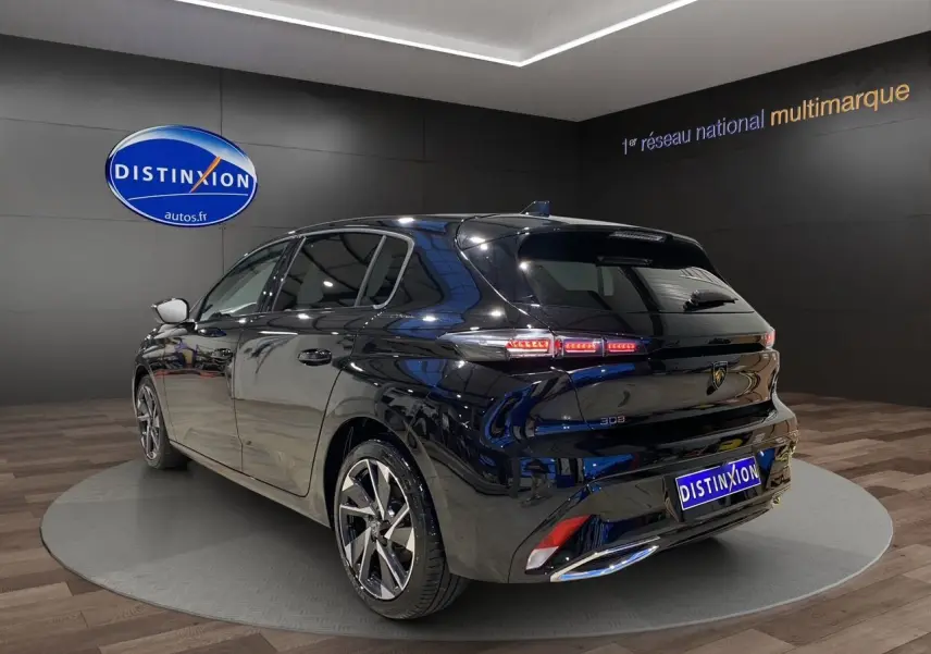 PEUGEOT 308 noir perla nera vue 3/4 arrière droit en intérieur avec feux arrière LED allumés.