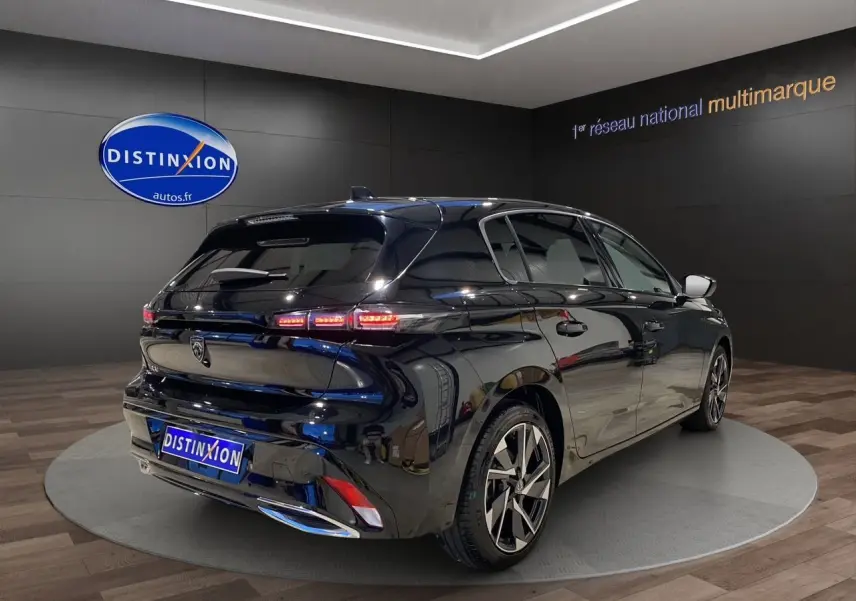 Vue 3/4 arrière droite d'une Peugeot 308 noire Perla Nera 2024 avec feux LED et jantes alliage distinctives.