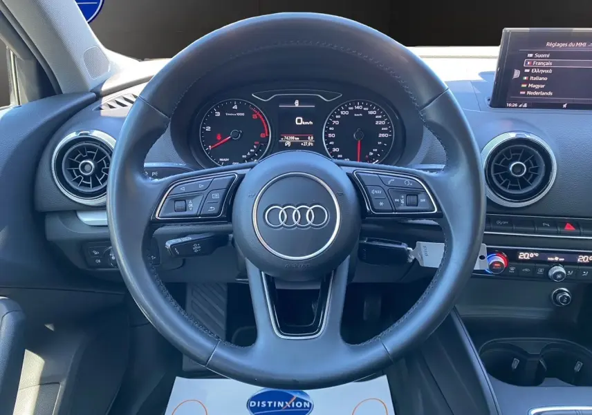 Vue rapprochée du volant cuir noir et du tableau de bord de l'Audi A3 Sportback 2020 avec affichage numérique et climatisation double zone.