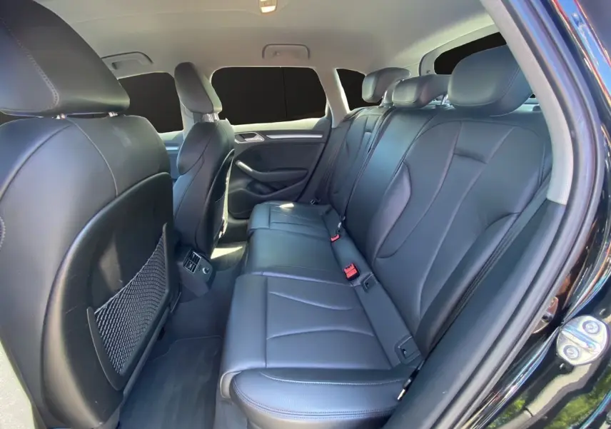 Vue intérieure arrière côté droit de l'Audi A3 Sportback noire 2020 avec sellerie cuir noir et sièges chauffants.