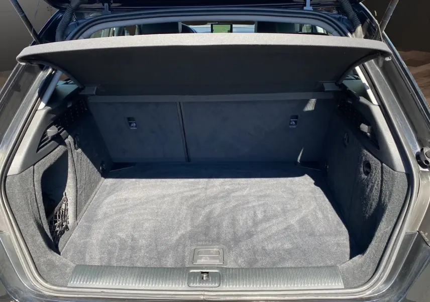 Coffre ouvert d'une Audi A3 Sportback noire, vue arrière, montrant un espace de chargement propre et bien aménagé.