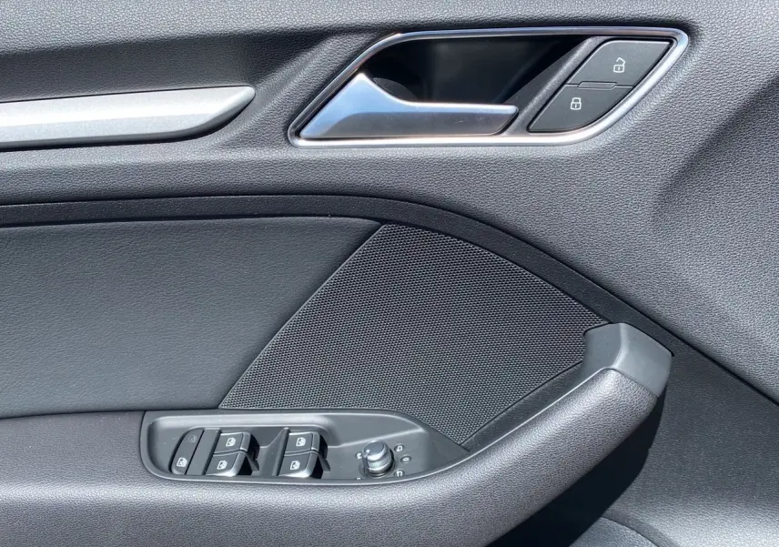 Détail de la porte côté gauche de l'Audi A3 Sportback noire 2020, avec commandes de vitres et verrouillage.