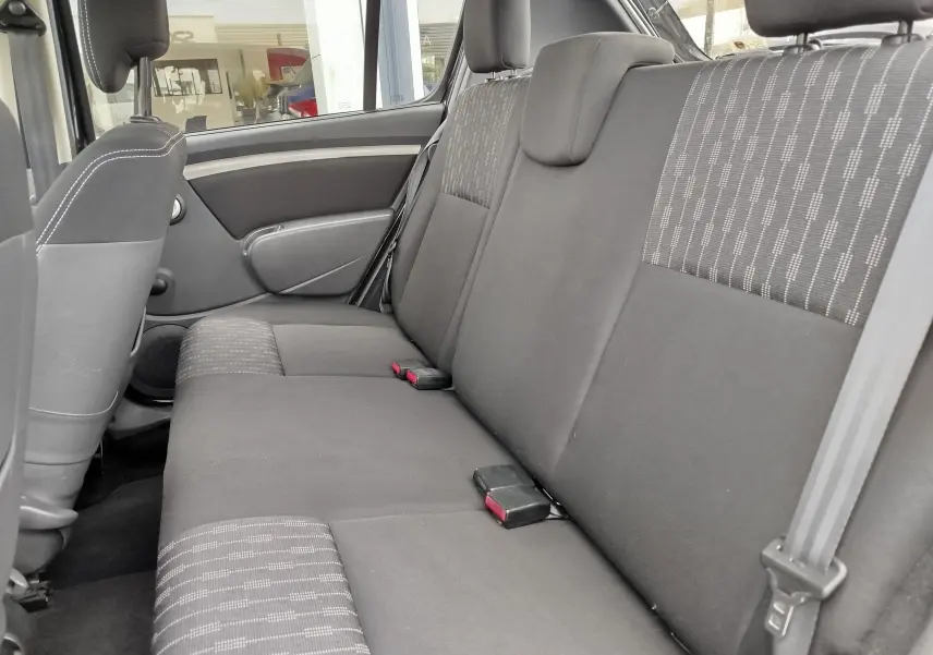 Vue latérale intérieure montrant la banquette arrière en tissu gris foncé avec motifs sur la DACIA SANDERO noire de 2011.