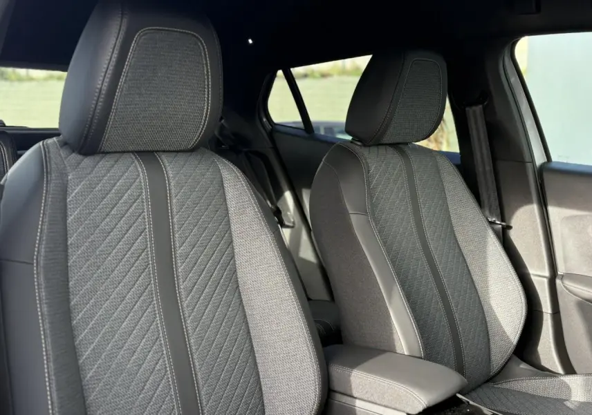 Gros plan sur les sièges avant gris et noirs du Peugeot 2008 Hybrid 145 e-DSC6 Allure, intérieur élégant et moderne.