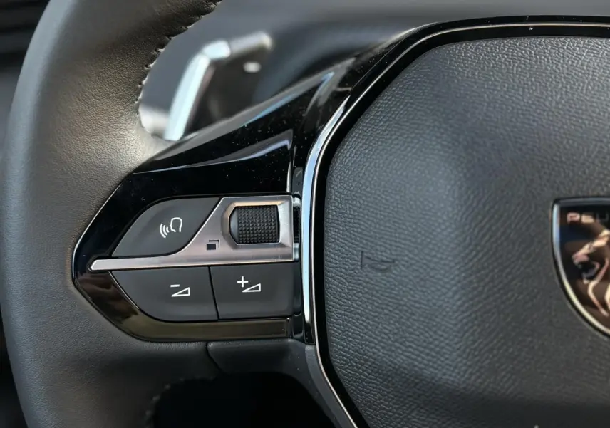 Gros plan sur la partie gauche du volant cuir noir du Peugeot 2008 Hybrid 145 e-DSC6 Allure 2025.