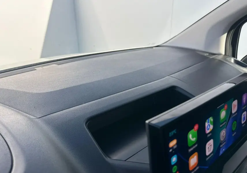 Vue rapprochée de la planche de bord noire du Citroën Berlingo III avec écran tactile 10 pouces en premier plan.