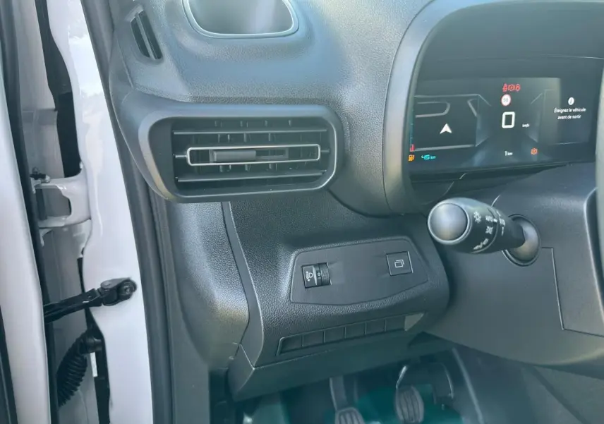 Vue intérieure côté conducteur du tableau de bord noir du Citroën Berlingo blanc avec écran numérique 10 pouces.