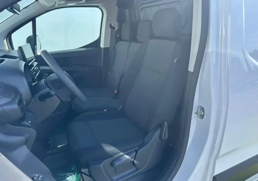 Vue intérieure côté conducteur du Citroën Berlingo blanc Icy, montrant les sièges tissu et le tableau de bord avec écran tactile.