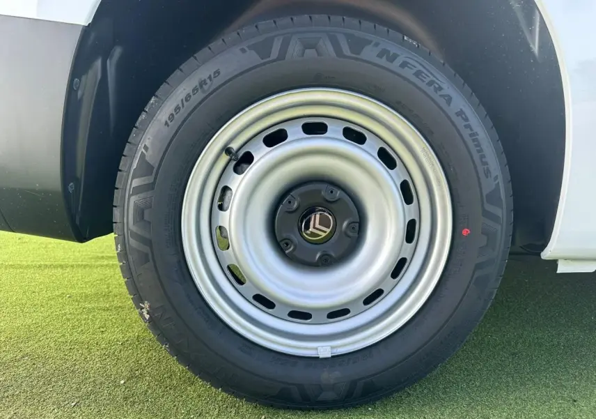 Gros plan sur la roue arrière droite en jante tôle grise du Citroën Berlingo blanc Icy 2026.