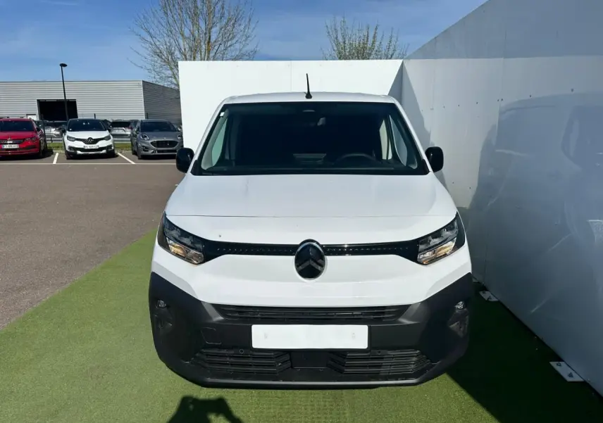 Vue de face d'un Citroën Berlingo blanc Icy avec pare-chocs noir mat et calandre épurée sur fond extérieur.
