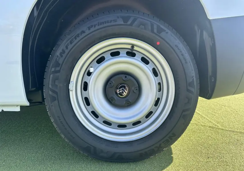 Gros plan sur la roue arrière droite du Citroën Berlingo blanc Icy avec jante tôle grise et logo Citroën au centre.