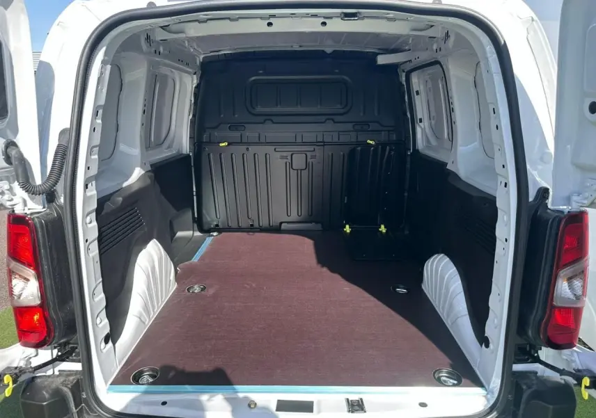 Vue arrière ouverte du Citroën Berlingo blanc Icy montrant l’espace de chargement avec plancher bois antidérapant.