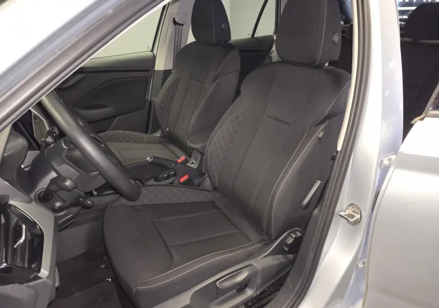 Vue intérieure côté conducteur du Skoda Kamiq gris 2023, sièges tissu noir avec surpiqûres contrastées.
