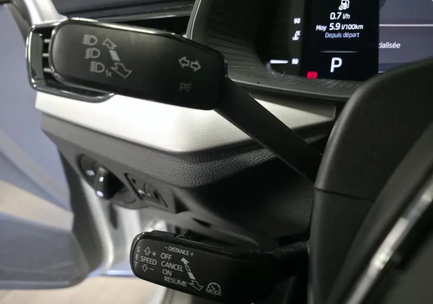 Gros plan sur les commandes au volant du Skoda Kamiq 2023 gris, avec affichage digital en arrière-plan.