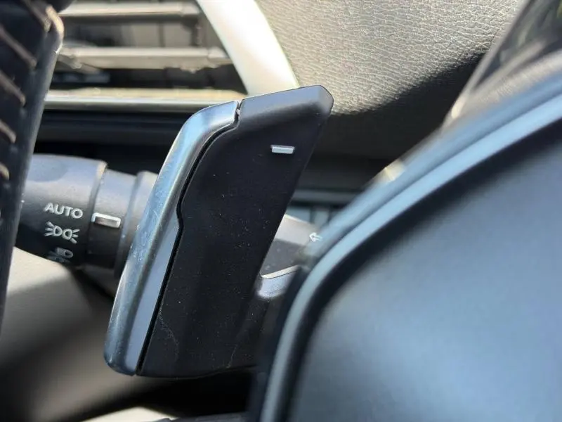 Gros plan sur la palette de changement de vitesse noire côté droit du volant cuir du Peugeot 3008 Hybride Rechargeable 2024.