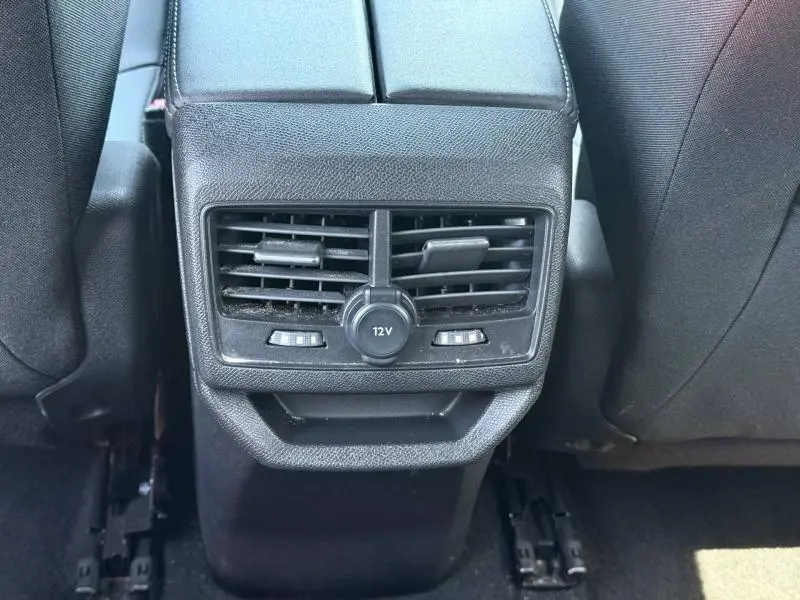 Vue rapprochée de la console arrière noire avec prise 12V et aérateurs du Peugeot 3008 Hybride Rechargeable 2024.